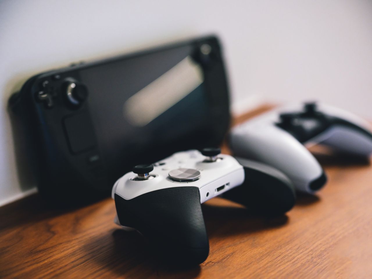 heros-img Stylish setup of gaming controllers and console on wooden surface.