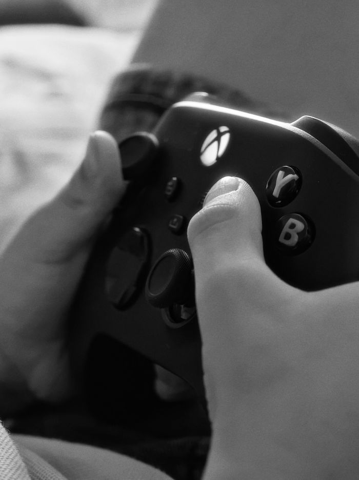 Close-up black and white photo of hands gripping a video game controller.