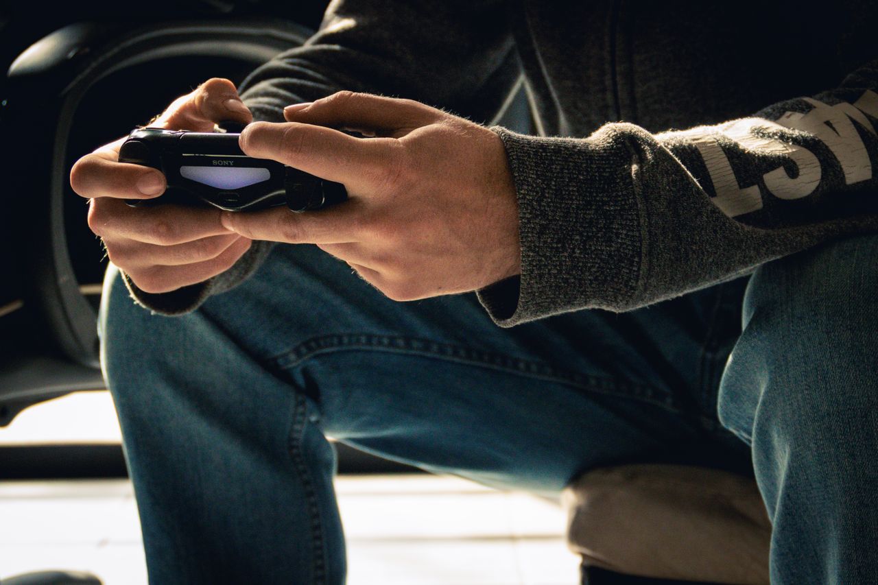 services-01 A close-up image of hands holding a game controller, emphasizing a gaming session indoors.